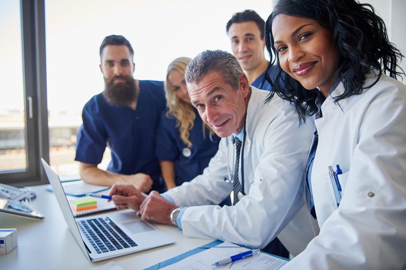 Health care website design photo of doctors surrounding a laptop